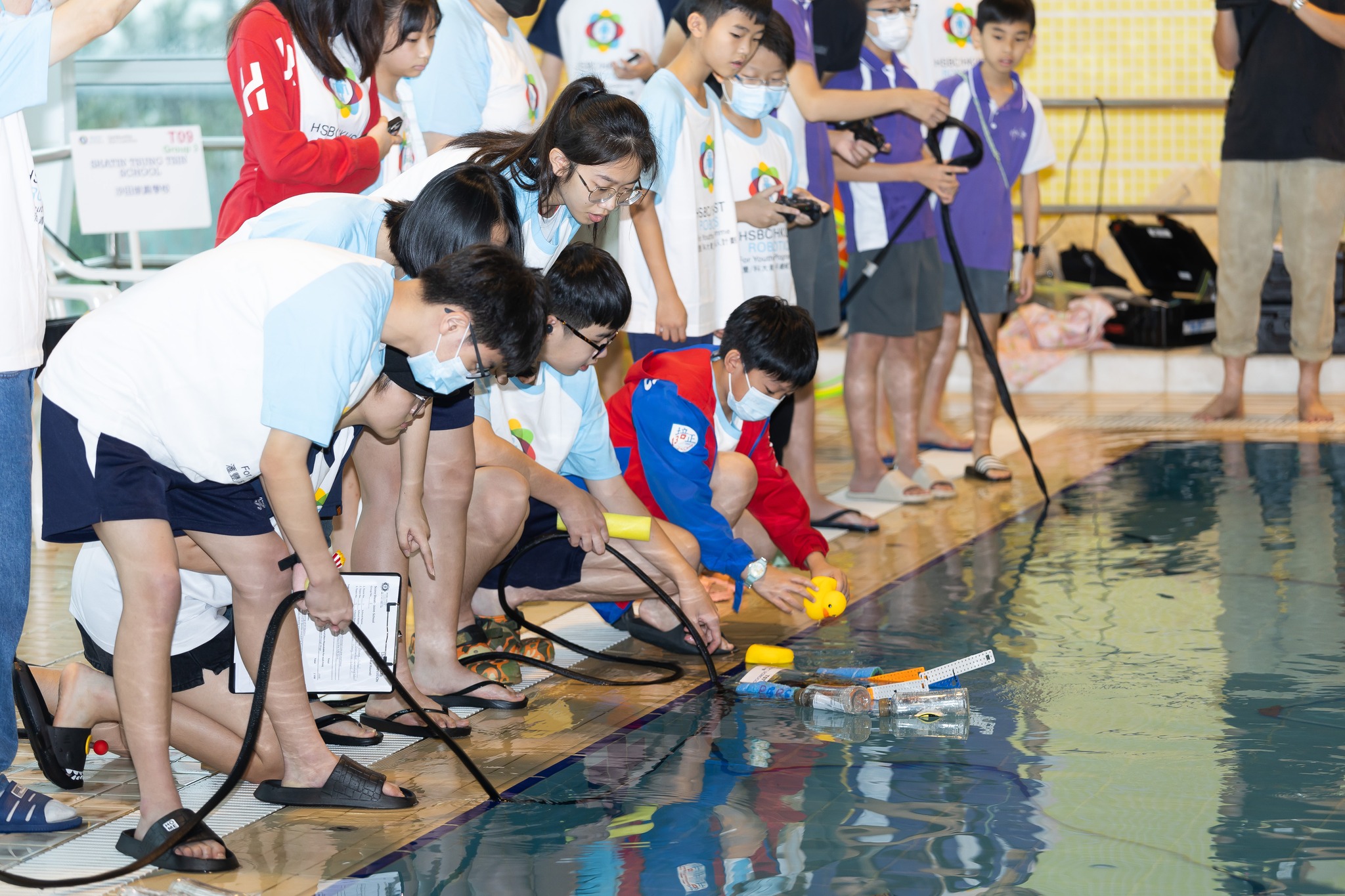 Participants guide the robots through various tasks: collecting toy sea creatures from the pool bottom, navigating obstacles, and completing precision manoeuvres. 