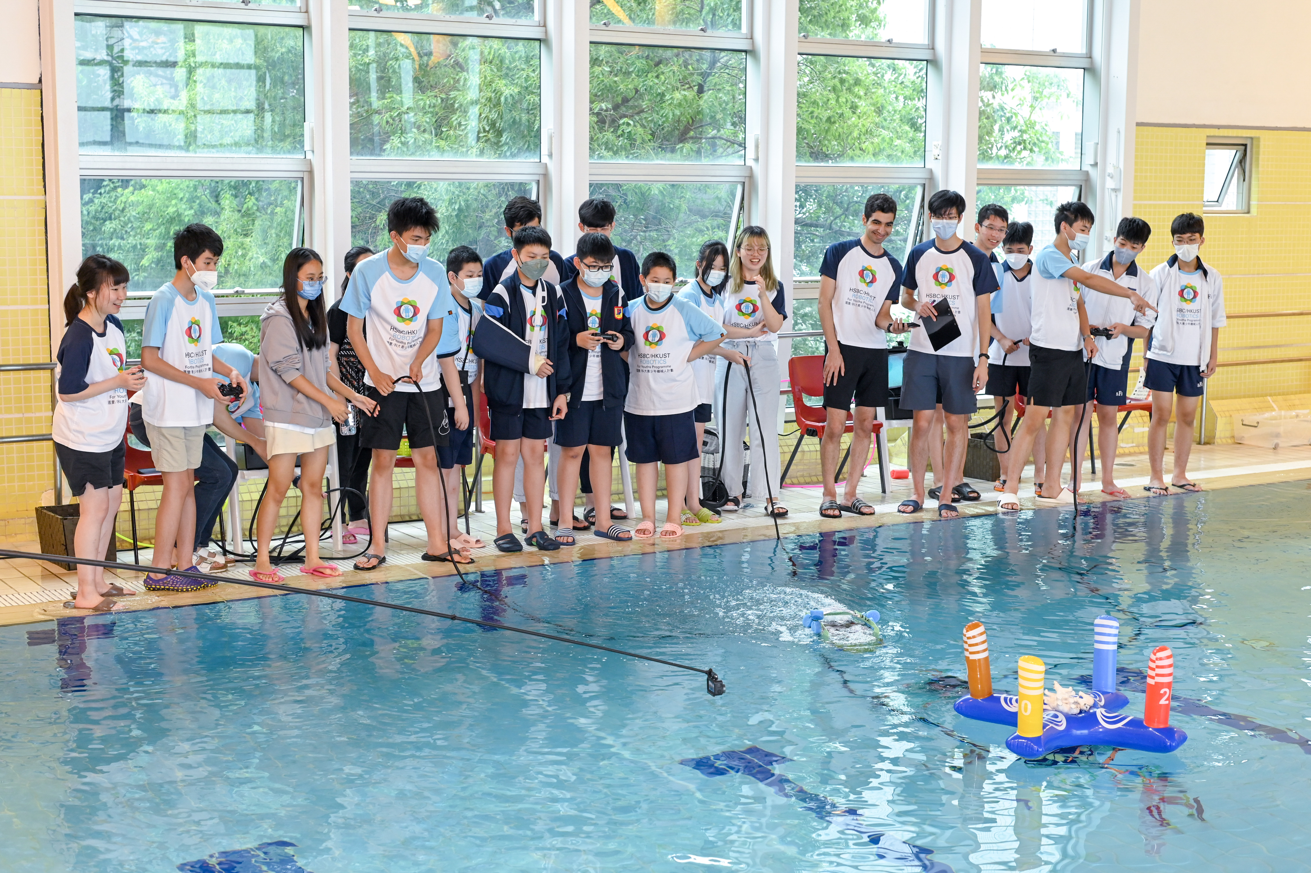 Participants guide the robots through various tasks: collecting toy sea creatures from the pool bottom, navigating obstacles, and completing precision manoeuvres. 