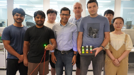 A group photo of Prof. Abhishek K. Srivastava (first row, center), Dr. Maksym Prodanov (first row, second right) and PhD candidate Mr. Kumar Mallem (first row, second left) with members of their research team. In the photo, Dr. Prodanov holds three bottles with quantum rod materials while Mr. Mallem holds a green emitting QRLED sample. A group photo of Prof. Abhishek K. Srivastava (first row, center), Dr. Maksym Prodanov (first row, second right) and PhD candidate Mr. Kumar Mallem (first row, second left) with members of their research team. In the photo, Dr. Prodanov holds three bottles with quantum rod materials while Mr. Mallem holds a green emitting QRLED sample.