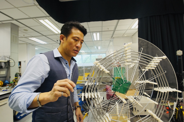 Prof. Patrick Yue demonstrates a wirelessly powered visible light communication (WP VLC) system designed by his graduate students.