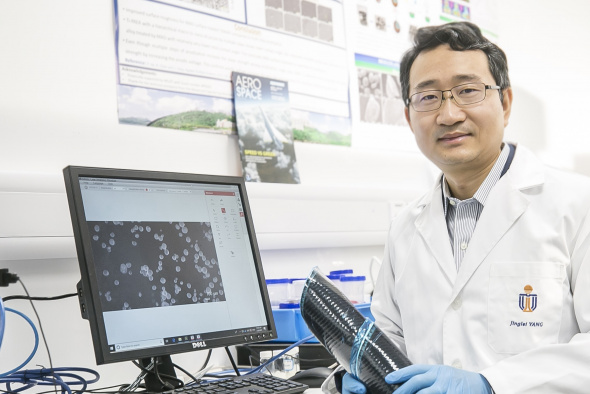 Prof. Yang Jinglei uses carbon fiber reinforced polymer composite (in his hands) and versatile microcapsules (shown on display) to manufacture self-healing, fire-resistant, and impact-proof multifunctional structures, contributing to a lightweight and safer solution for aircraft and electric vehicles.