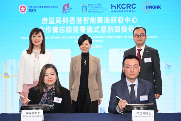 Witnessed by the Secretary for Housing, Ms. Winnie Ho (back row, center), the Acting Secretary for Innovation, Technology and Industry, Ms. Lillian Cheong (back row, left), and the Chairman of the Board of the HKCRC, Dr. Shin Cheul Kim (back row, right); the Associate Director of the HKCRC, Dr. Liang Haobo (front row, right), and the Permanent Secretary for Housing/Director of Housing, Miss Rosanna Law (front row, left), signed the Memorandum of Understanding.
