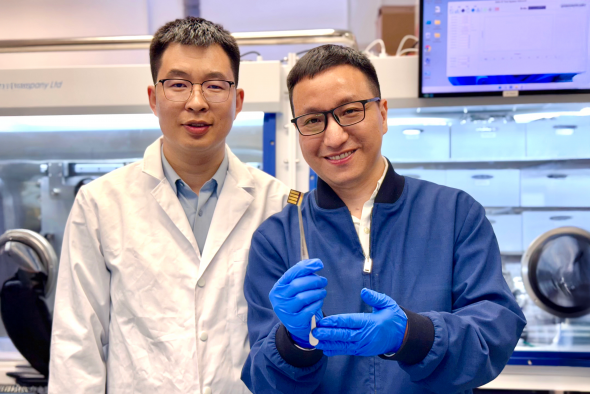 The lead corresponding author Prof. Zhou Yuanyuan (right) and co-first author Dr. Guo Pengfei (left) are showing a perovskite solar cell prototype made for a proof-of-concept demonstration of the novel laminate-structured interface.