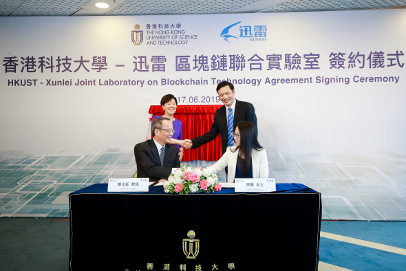 Prof. Tim CHENG, Dean of Engineering of HKUST (front left), and Ms. LAI Xin, ThunderChain’s Chief Engineer of Xunlei (front right), sign the collaborative agreement to establish HKUST-Xunlei Joint Laboratory on Blockchain Technology, witnessed by Prof. Nancy IP, Vice-President for Research and Development of HKUST (back left), and Mr. CHEN Lei, Chief Executive Officer of Xunlei and Onething Technologies (back right)