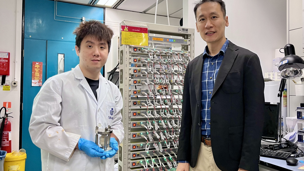 Prof. Yoonseob Kim (right), Associate Professor in the Department of Chemical and Biological Engineering and the study’s corresponding author, stands with his PhD student Gu Muhua (left), the paper’s first author, who is holding a solid-state battery cell mold. They are pictured beside a battery cell cycler.