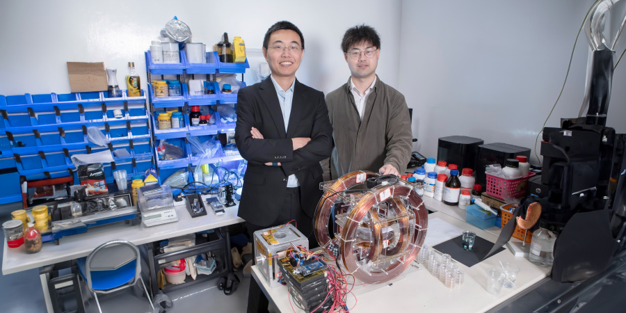 Prof. Shen Yajing (left) and co-first author Dr. Yang Xiong (right) with the magnetic actuation platform for microswimmer control in front.