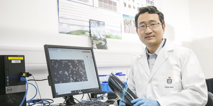 Prof. Yang Jinglei uses carbon fiber reinforced polymer composite (in his hands) and versatile microcapsules (shown on display) to manufacture self-healing, fire-resistant, and impact-proof multifunctional structures, contributing to a lightweight and safer solution for aircraft and electric vehicles.