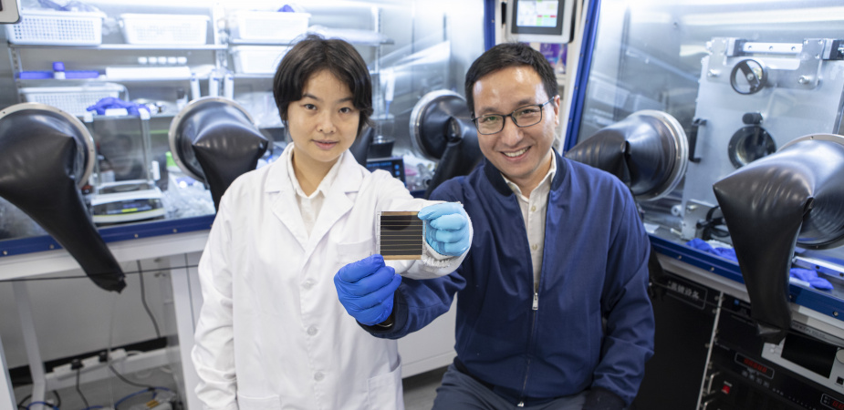 Prof. Zhou Yuanyuan (right) and Dr. Duan Tianwei (left) holding their newly developed perovskite solar cell.