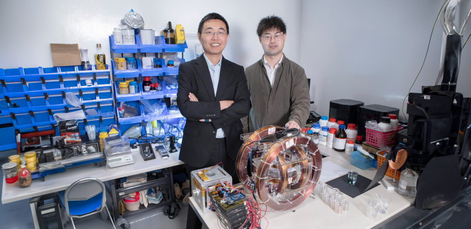 Prof. Shen Yajing (left) and co-first author Dr. Yang Xiong (right) with the magnetic actuation platform for microswimmer control in front.