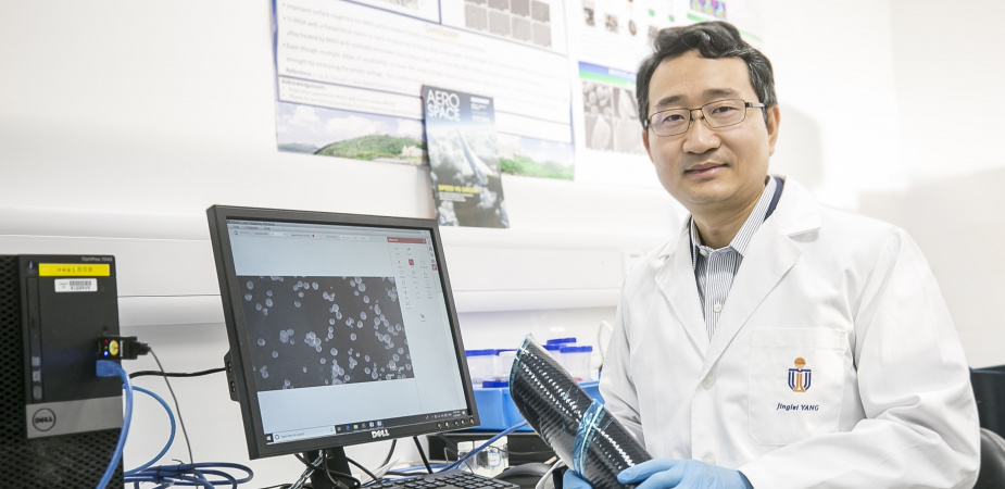 Prof. Yang Jinglei uses carbon fiber reinforced polymer composite (in his hands) and versatile microcapsules (shown on display) to manufacture self-healing, fire-resistant, and impact-proof multifunctional structures, contributing to a lightweight and safer solution for aircraft and electric vehicles.