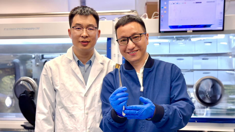 The lead corresponding author Prof. Zhou Yuanyuan (right) and co-first author Dr. Guo Pengfei (left) are showing a perovskite solar cell prototype made for a proof-of-concept demonstration of the novel laminate-structured interface.