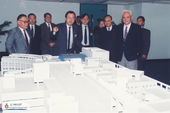 钟博士（前左一）于1992年为到访科大的时任国务院港澳办公室主任鲁平（前右一）介绍科大发展计划。