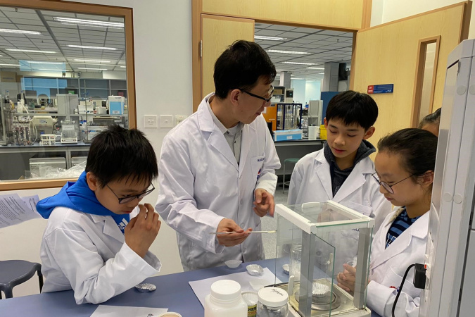 In laboratory experiments, Prof. Liu (second left) guides students to reflect on the science behind while making food together.