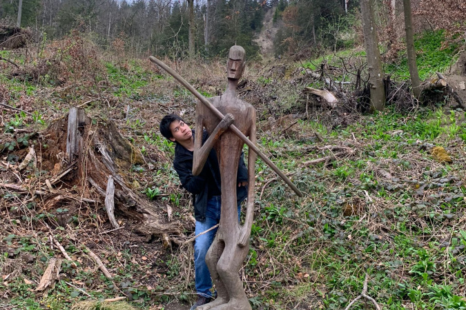 A photo of me with a statue I found while hiking the most popular mountain in Zürich, Uetliberg. It is a popular hiking spot for most local people in Zürich, and the statue is unidentified but told to me that it is likely an homage to the indigenous people of the mountains before. 
