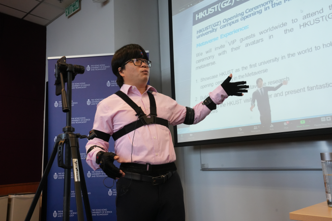 Prof. Pan Hui, Director of the Center for Metaverse and Computational Creativity (MC2) at HKUST, demonstrates how the center’s research work refines the avatar’s (the figure on the screen) facial expressions and body movements with sensors and facial expression capturing technology.