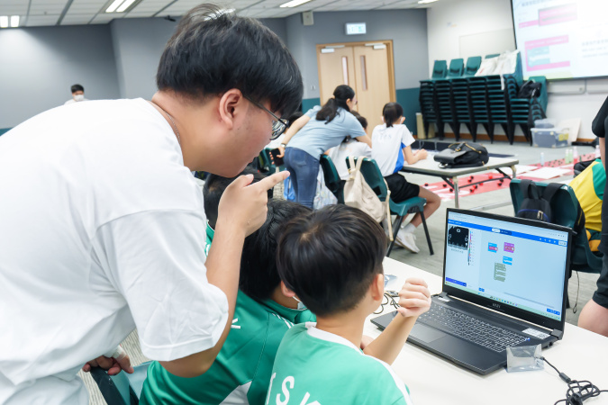 A HKUST student helper instructed a team in coding the micro:bit.