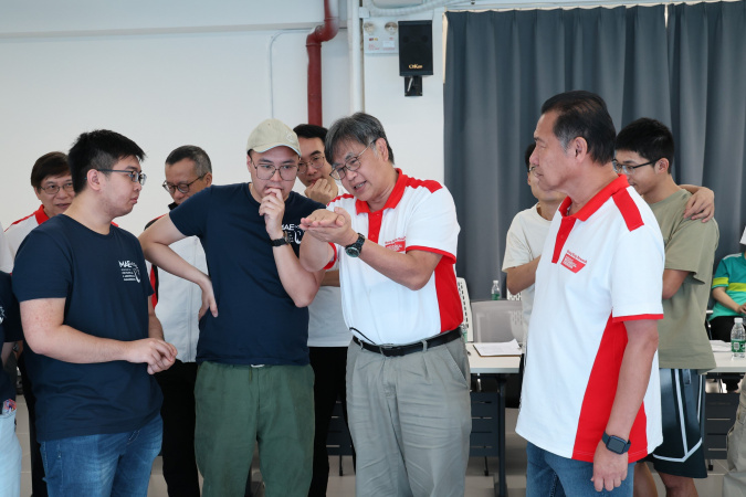 The HKUST team introduced their vehicle to judges Ir Eric Lim (second right) and Ir Louis Szeto (first right).