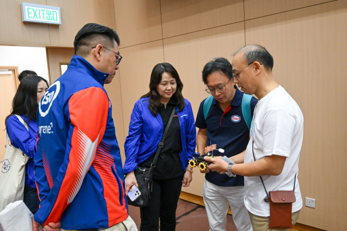 嘉賓細心聆聽關於劍擊機械人設計概念的講解。
