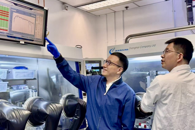 Prof. Zhou Yuanyuan (left) is guiding Dr. Guo Pengfei (right) in analyzing the stability test results of perovskite solar cells based on laminated-structured interfaces.