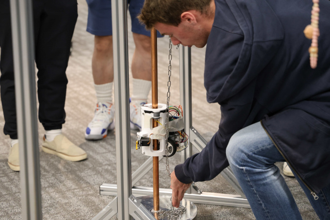 The climbing device needs to climb a vertical pipe while carrying an increasing load and maintaining stable attachment to the pipe surface.