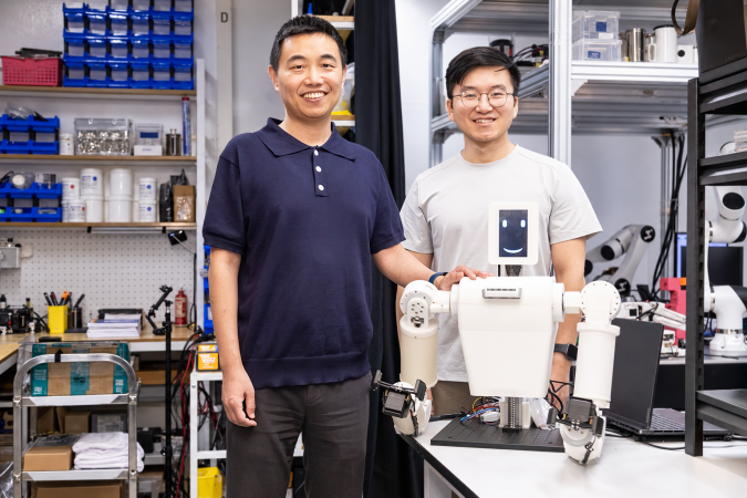 Prof. Shen Yajing (left), corresponding author of the study, and Dr. Tang Yifeng (right), first author of the paper, with the EmArm system.