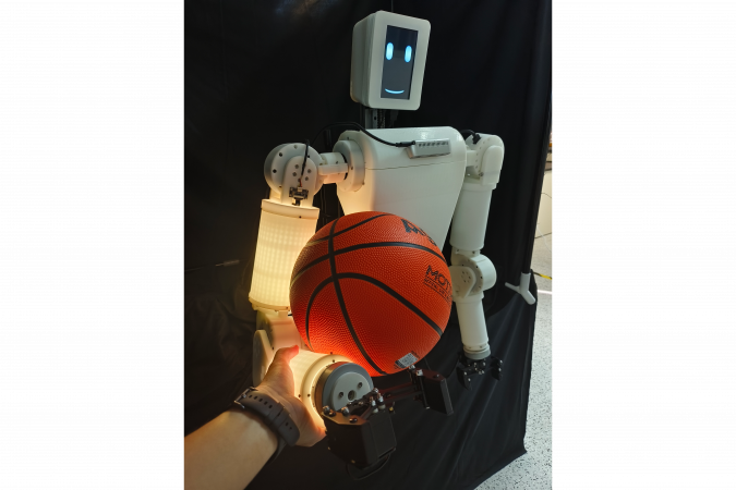 While holding an off-center basketball and interacting with a human hand, EmArm continuously integrates proprioceptive and tactile signals to adjust its posture and stabilize the object.