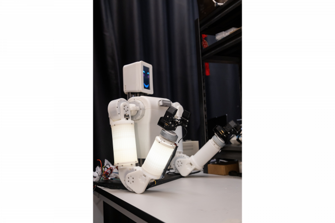 EmArm embeds a soft optical tactile “skin”, shown as the illuminated surfaces, within its rigid mechanical skeleton. Combined with real-time decision-making algorithms, the tactile skin enables whole-arm tactile sensing and adaptive manipulation.