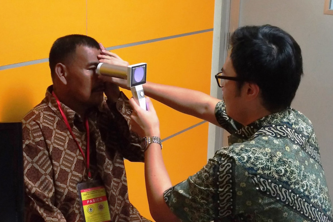 學生於印尼一間診所內，測試使用手提式眼底相機檢測糖尿眼的效果。