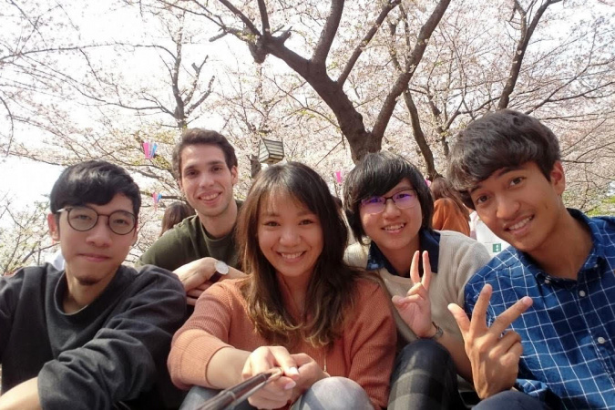 Alumna CHAU Wing-In (second right) gets along well with her friends and colleagues in Japan.  They engaged in the Japanese practice of Hanami – having a picnic and enjoying the cherry blossoms.
