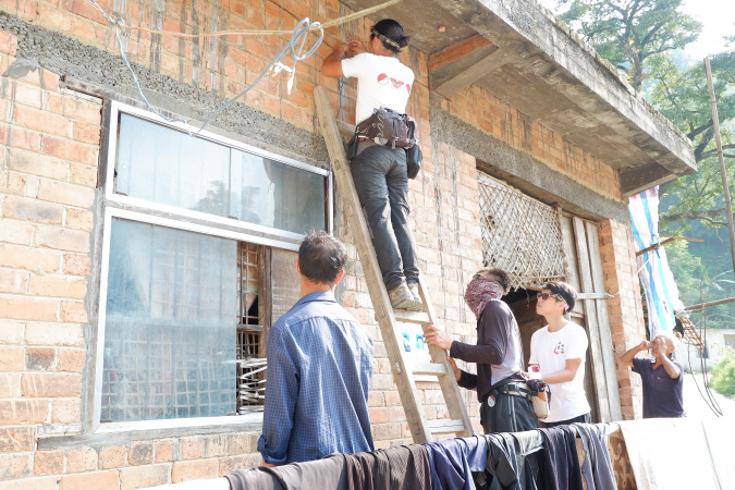 學生義工們和督導老師為村民家居修繕電路。