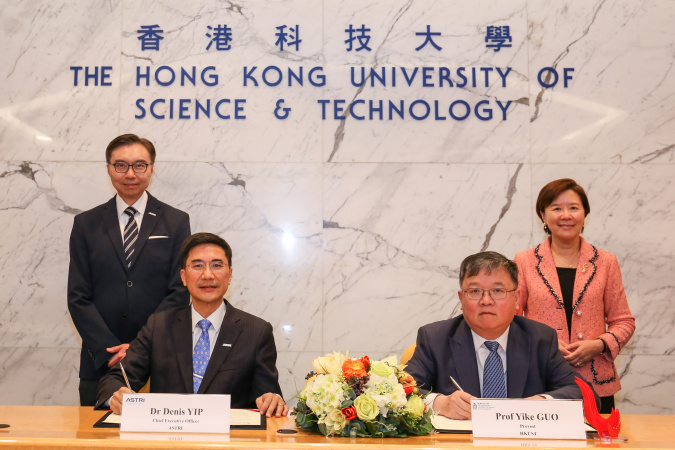 ASTRI Chief Executive Officer Dr. Denis Yip (front left) and HKUST Provost Prof. Guo Yike (front right) sign the agreement under the witness of HKUST President Prof. Nancy Ip (back row, right) and Chairman of ASTRI Board of Directors Ir. Sunny Lee (back row, left).