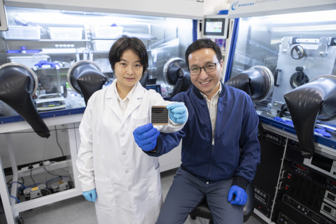 Prof. Zhou Yuanyuan (right) and Dr. Duan Tianwei (left) holding their newly developed perovskite solar cell.