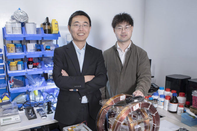 Prof. Shen Yajing (left) and co-first author Dr. Yang Xiong (right) with the magnetic actuation platform for microswimmer control in front.