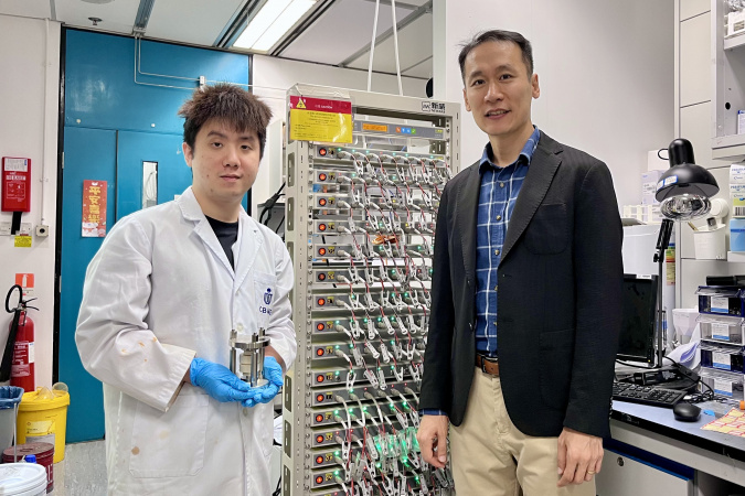Prof. Kim Yoonseob (right), Associate Professor in the Department of Chemical and Biological Engineering and the study’s corresponding author, stands with his PhD student Gu Muhua (left), the paper’s first author, who is holding a solid-state battery cell mold. They are pictured beside a battery cell cycler.