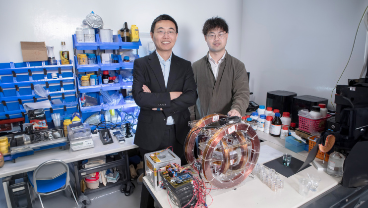 Prof. Shen Yajing (left) and co-first author Dr. Yang Xiong (right) with the magnetic actuation platform for microswimmer control in front.