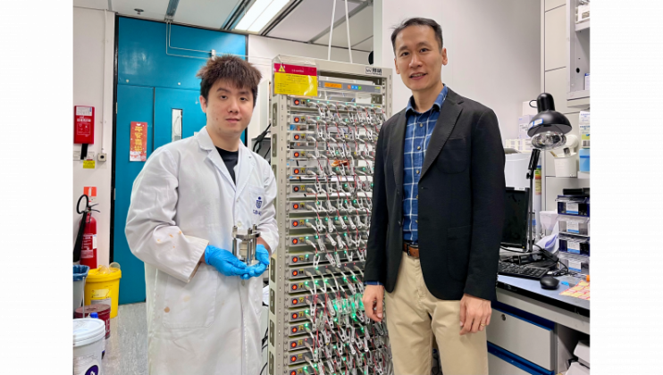 科大化学及生物工程学系副教授兼论文的通讯作者金允燮教授（右）和其博士生兼论文第一作者古穆华（左；手持固态电池模具）站在电池充放电循环仪旁合影。 